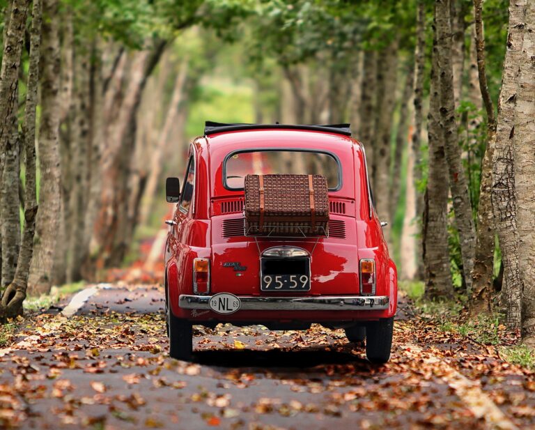 Une petite voiture rouge Fiat 500 avec des bagages qui roule pour symboliser le nouveau départ grâce à la psychogénéalogie à Toulon